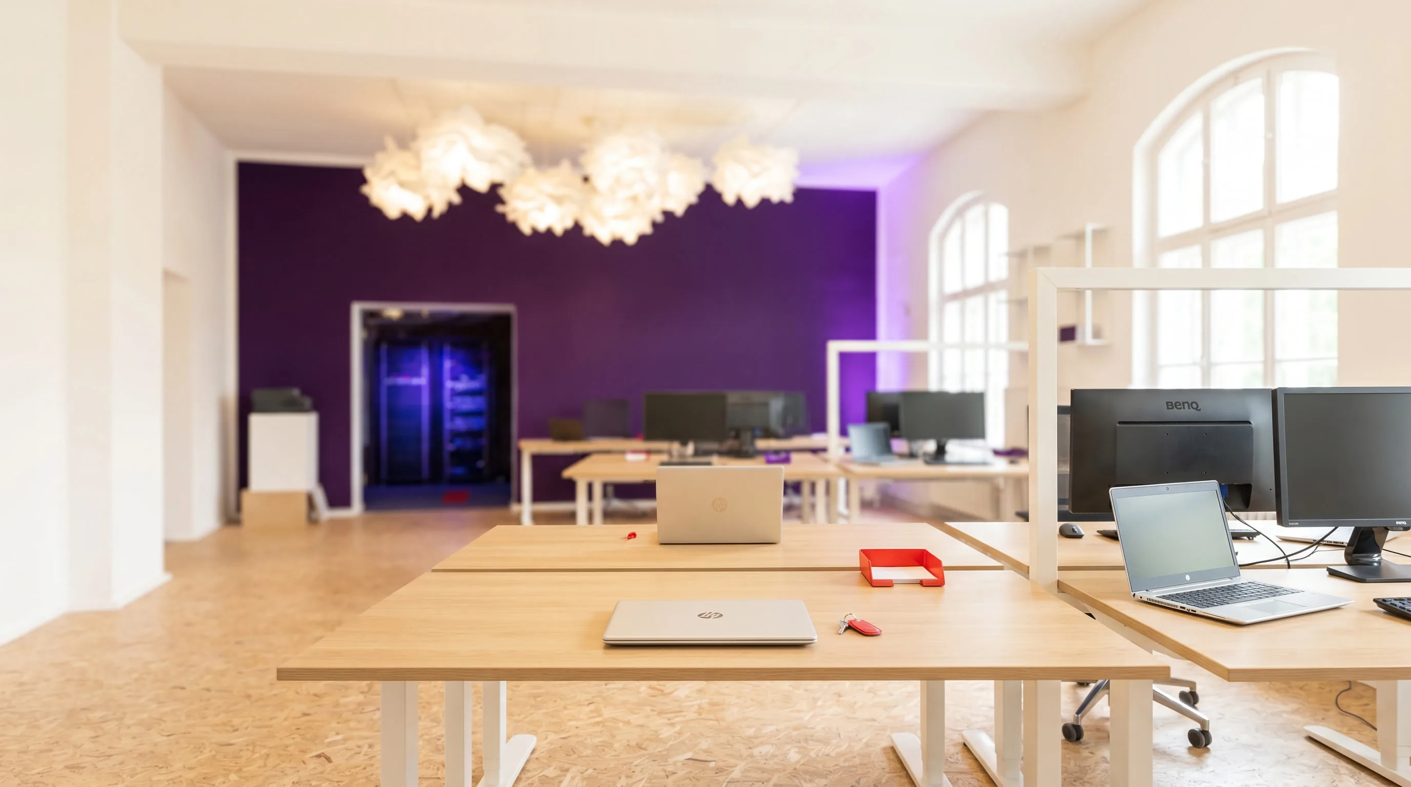 Arbeitsplätze in einem Großraumbüro mit einheitlich ausgestatteter Business-Hardware — beschafft und verwaltet von implec