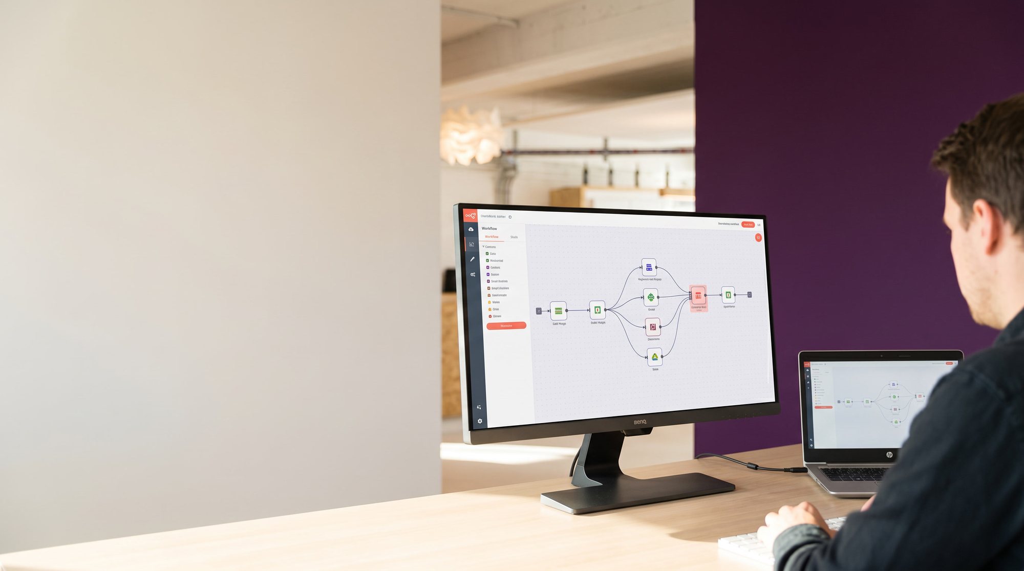 Mitarbeiter am HP-Notebook und BenQ-Monitor mit Automations-Workflow vor lila Akzentwand — KI & Automatisierung bei implec